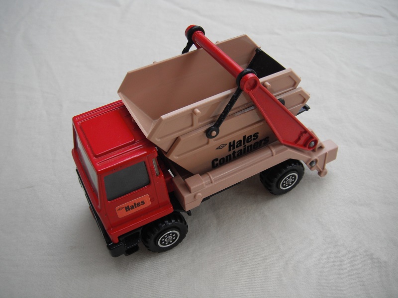 2.  Dark red cab/type 1 cab roof/tan skip/black base/Hales label on cab door/large steering wheel.