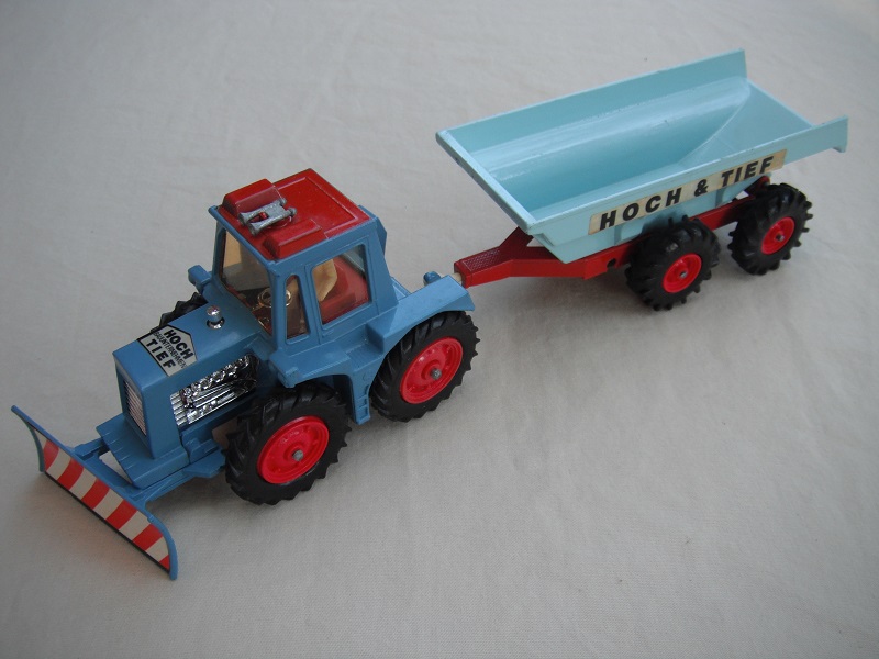 14. Blue tractor/type 2 plow/thin tires/clear windows/white driver/dark red interior/light blue &amp; dark red trailer/large tires/type 2 tow bar/Hoch &amp; Tief label.