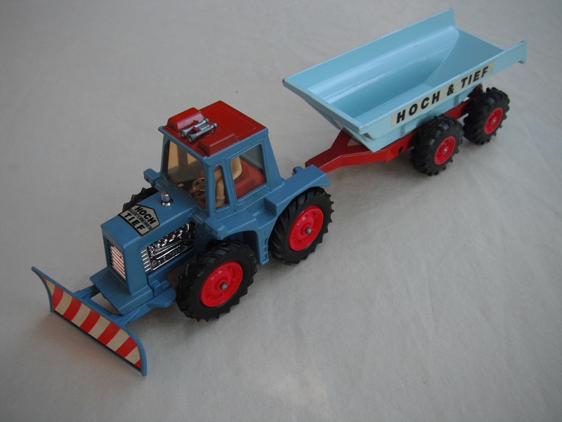 13. Blue tractor/type 2 plow/thin tires/clear windows/ white driver/red interior/light blue &amp; dark red trailer/large tires/type 2 tow bar/Hoch &amp; Tief label.