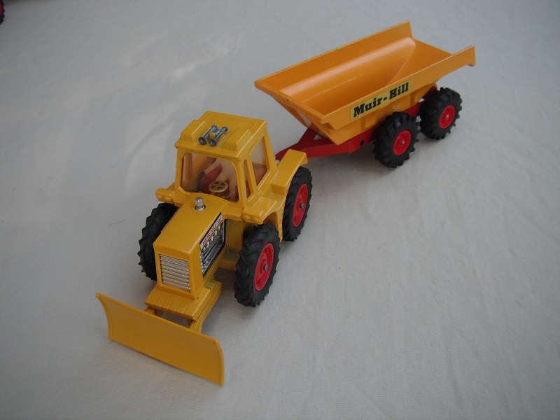 7. Yellow tractor/no stripes on plow/thin tires/light amber windows/translucent driver/dark red int/dark yellow &amp; dark red trailer/large tires/type 1 tow bar/Muir-Hill label.