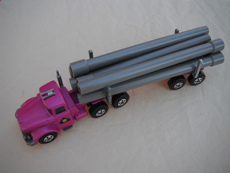 13. Metallic purple cab &amp; trailer/large 5 spoke front wheels &amp; rear/light tan axle cover/square hook/gray pipes.