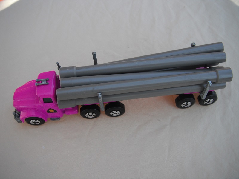 11. Pinkish purple cab &amp; trailer/unpainted base/large 5 spoke front wheels &amp; rear/light tan axle covers/square hook/gray pipes.