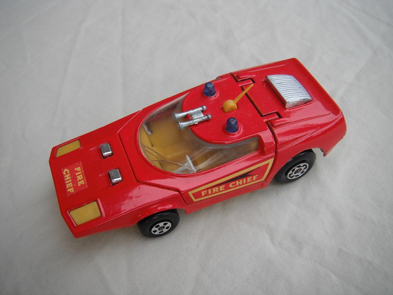 11. Bright red body/yellow base/blue dome lights/clear window/orange-yellow interior/yellow antenna/Fire Chief labels.