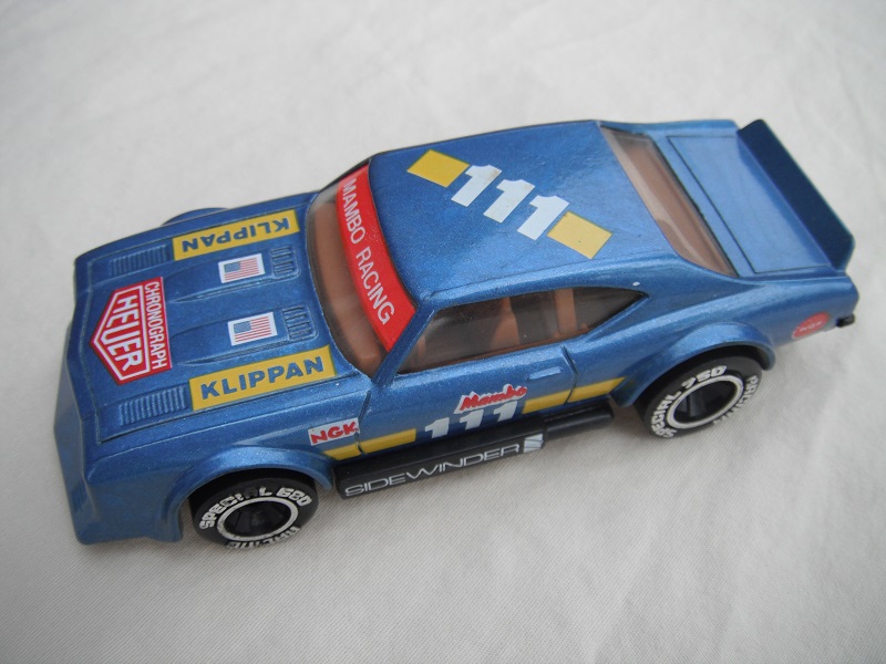 11. Dark metallic blue body with yellow stripe/black base Macau/brown interior/clear windows/chromed lettering on wheels/Mambo #111.