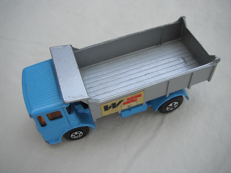 21. Lt.blue cab/silver tipper/silver base/cast block/5 spk whls/blk xle cvr f.aft/amb wind/blue plastic front &amp; blue on base/W.Wates label/in #3 tailgate.