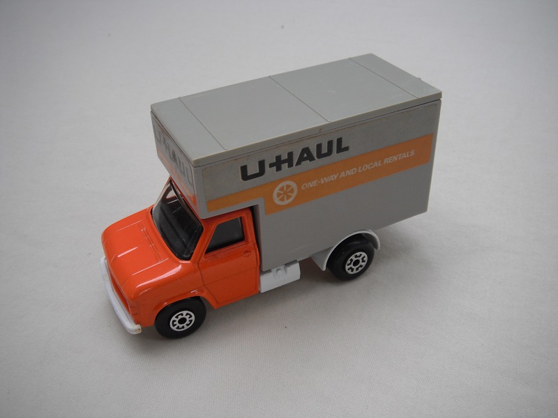 18. Org cab/wht base/gry roof/clear windows/5 arch(f)5 crown(r) wheels/org axle cover/U Haul labels.