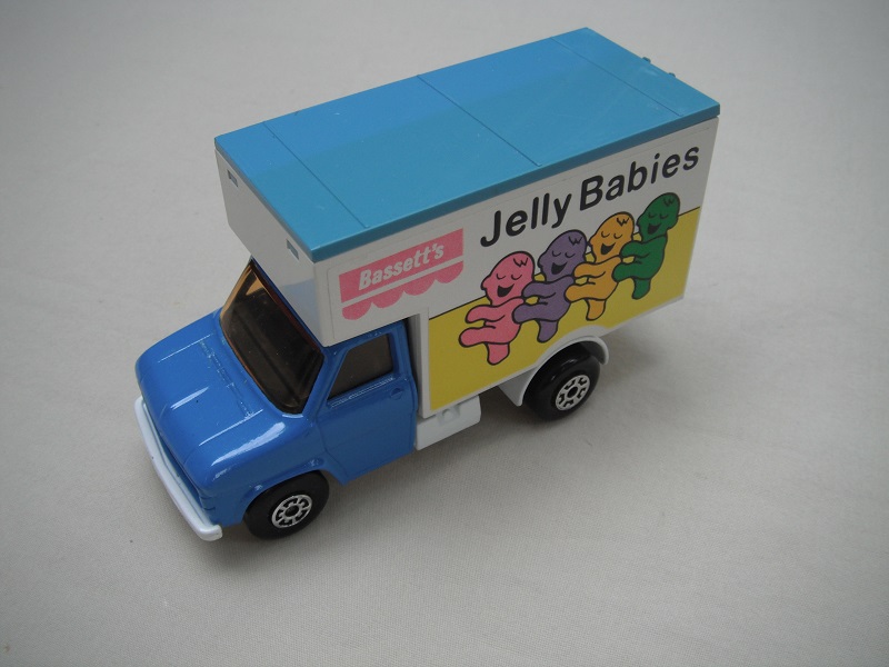 8. Blue cab/wht base/lt.blu roof/lt.amber windows/5 arch(f)5 crown(r) wheels/blk axle cover/Jelly Babies labels.