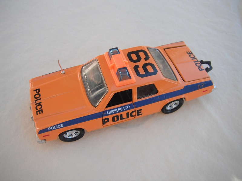 28. Orange body/dk.blue stripe/black China base/black int/clear windows/no trim/blue dome lights/orange frame/Lindberg City Police decals.