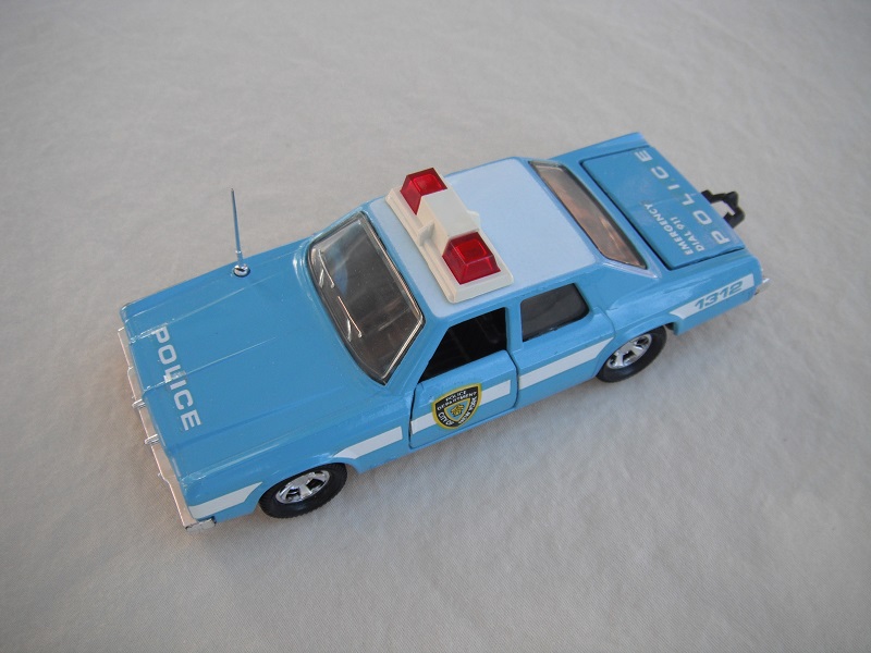 11. Pale blue body/white roof/black England base/light blue interior/clear windows/no trim/red dome lights/white frame/NYC Police decals.