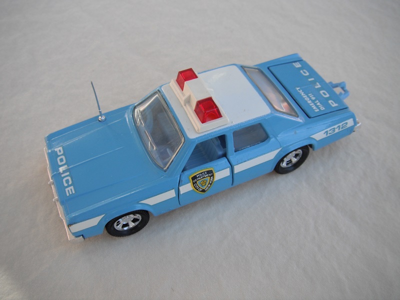 9. Lt. blue body/white roof/black England base/black interior/clear windows/no trim/red dome lights/white frame/NYC Police decals.