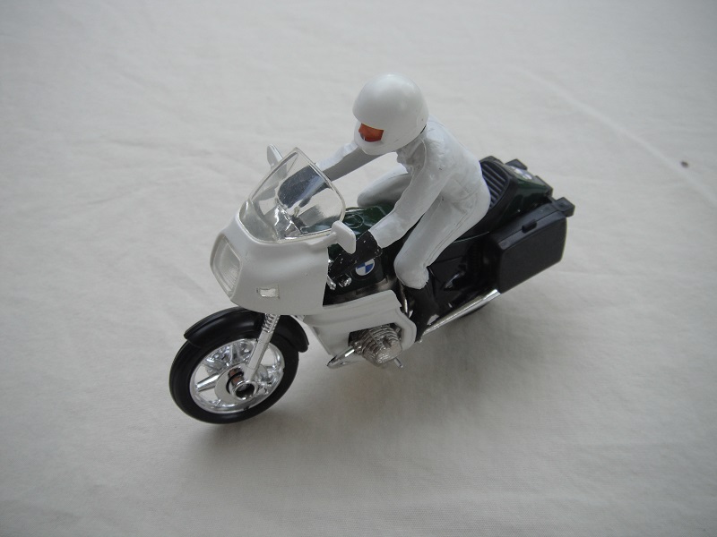 9. Green &amp; white MC/clear windshield/blk saddle bags/driver in white/black boots &amp; gloves/white helmet/no visor/BMW.