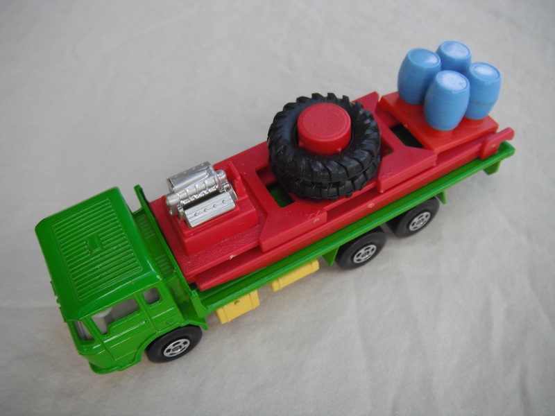 7. Lt.green body/lt.yellow K-13/20 base/clear windows/wht int/5 spoke star wheels/blk open axle cover/dk.red ramp/blue barrels.