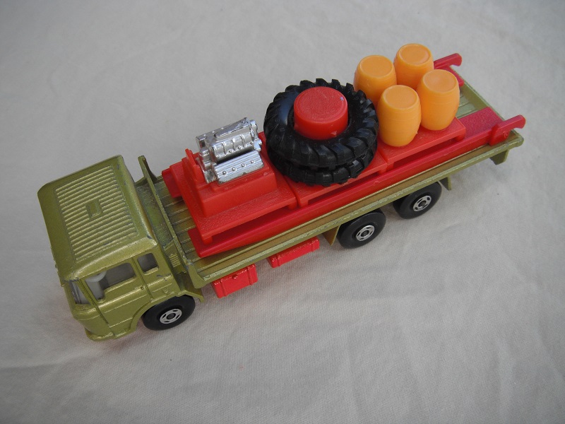 2. Olive green body/red K-13/20 base/clear windows/wht int/4 spoke wheels/blk open axle cover/red ramp/dk.yellow barrels.