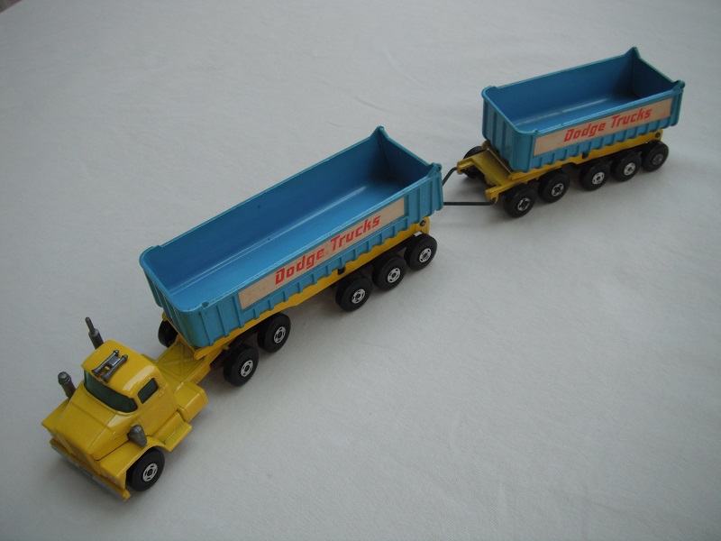 9.Dk.yellow cab &amp; base/lt.blu tipper/lt.blu front &amp; brn rear xle cvrs/type b tailgate/grn wind/Trailer w/brown xle cvrs/&quot;Dodge Trucks&quot;  in red.