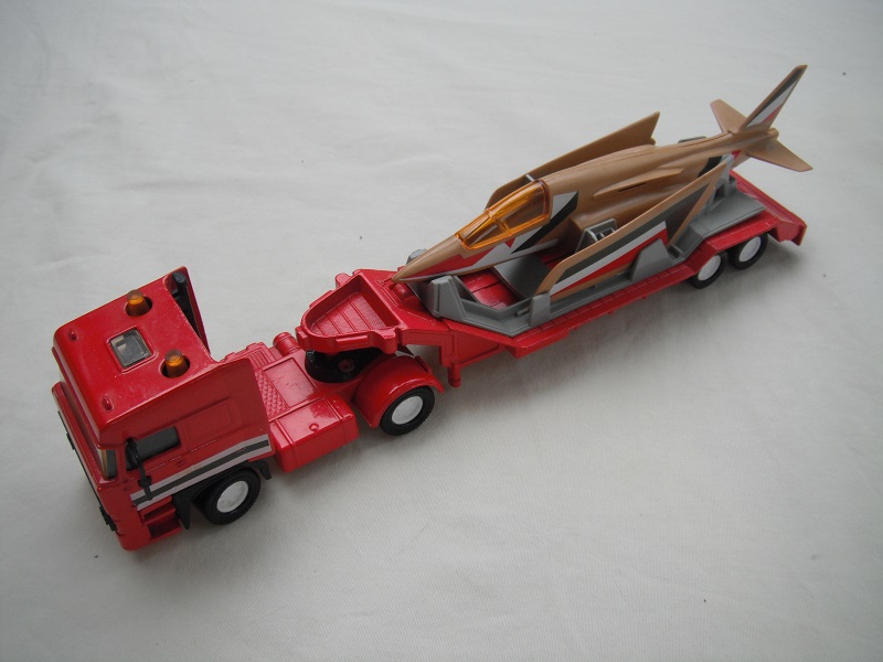 1. Red cab/red Macau base/wht 8 dot disc whls/amb dome lts/red trailer/gray cradle/brown jet plane/amber cockpit/stripes.