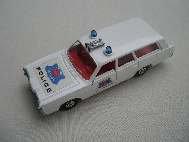 6. Off white body/silver base/spiro wheels/clear windows/red interior/blue Police labels on hood &amp; sides.