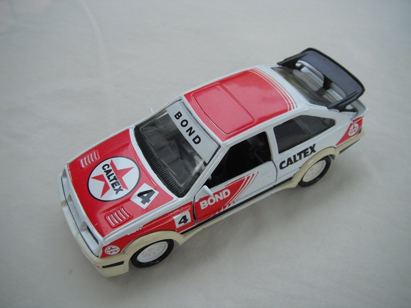 7. White &amp; red body/white Macau base/wht wire whls/blk int/clr windows/wht steering/Caltex.