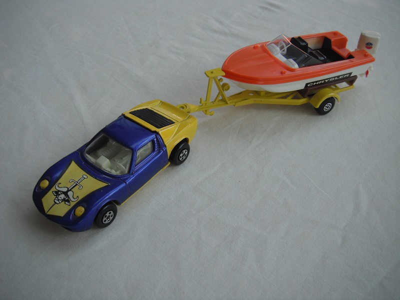 7. Blue&amp;yellow car/yellow base/5 spoke whls/clear windows/wht int/lt.yellow trailer type a/org deck boat/red prop/Chrysler label.