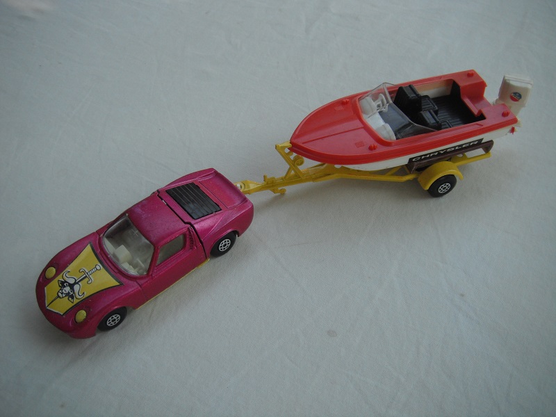 6. Burgundy car/yellow base/spiro whls/clear windows/wht int/dk.yellow trailer type b/red deck boat/red prop/Chrysler label.