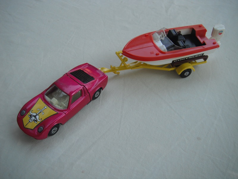 5. Burgundy car/unpainted base/spiro whls/clear windows/wht int/dk.yellow trailer type b/red deck boat/red prop/Chrysler label.