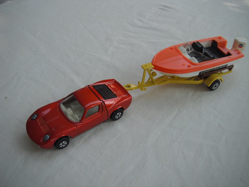 1. Bronze car/unpainted base/5 spoke whls/clear windows/wht int/dk.yellow trailer type a/org deck boat/blue prop/Chrysler label.