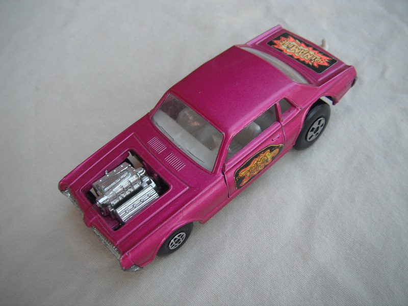 8. Purple body/unpainted England base/clear windows/spiro &amp; five spoke wheels/&quot;Dinamite&quot; label letters in dk.yellow.