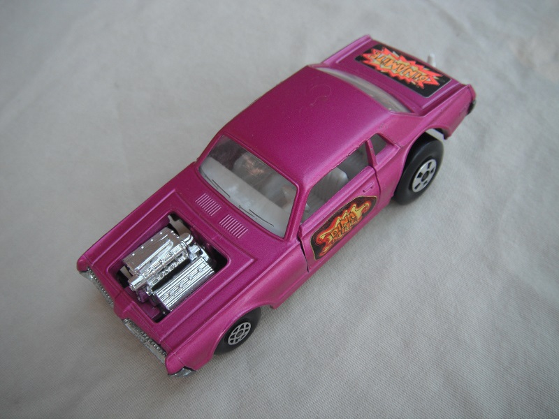 7. Lt. purple body/unpainted England base/clear windows/spiro &amp; five spoke wheels/&quot;Dinamite&quot; label letters in orange.