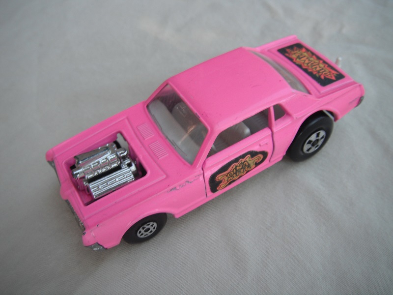 4. Med.pink body/unpainted England base/clear windows/spiro &amp; five spoke wheels/&quot;Dinamite&quot; label letters in dk.yellow.