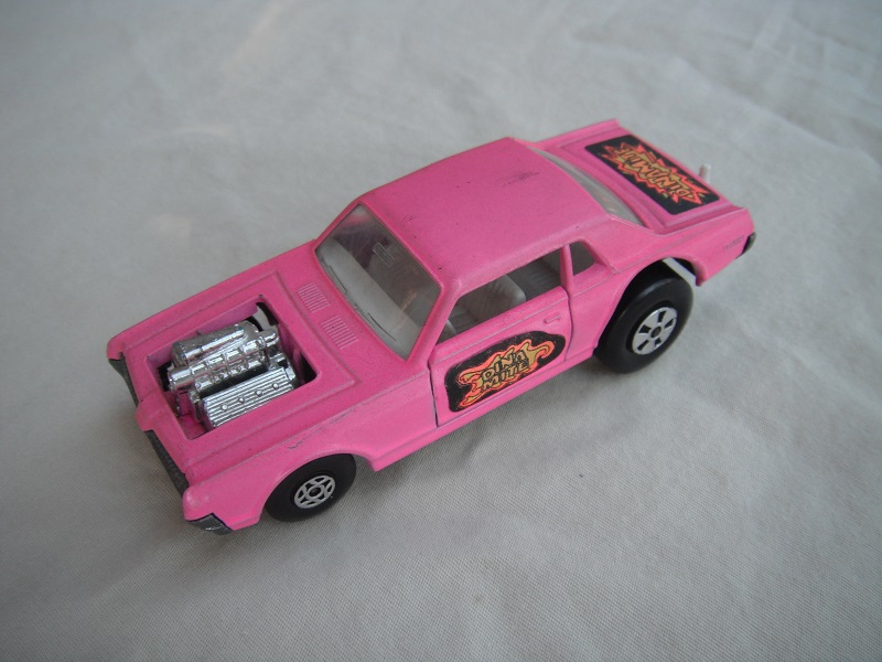 2. Lt.pink body/unpainted England base/clear windows/spiro &amp; five spoke wheels/&quot;Dinamite&quot; label letters in dk.yellow.