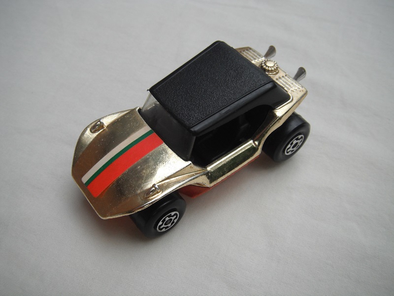 12.Gold plated body/blk roof/lt.orange base/MC wheels/clear windshield/blk int/stripes label/mounted on ashtray.