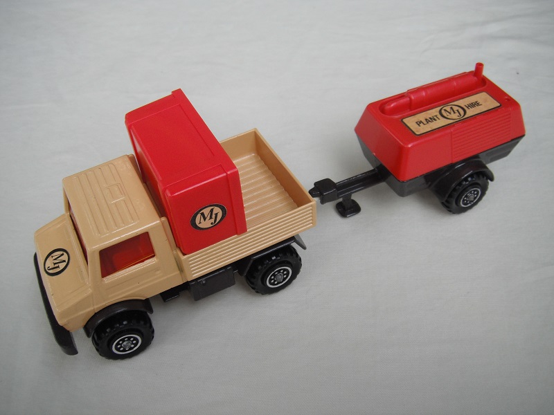 3. Tan body/red grill/dk.brown base/8 dot ringed wheels/red windows/dk.brown trailer/red cover/MJ labels.