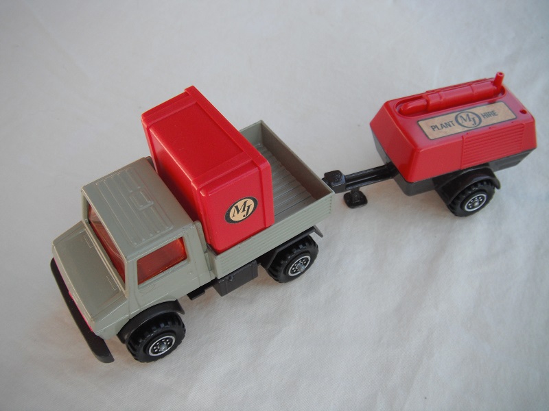 1. Gray body/red grill/dk.brown base/ 8 dot ringed wheels/red windows/dk.brown trailer/red cover/MJ labels.