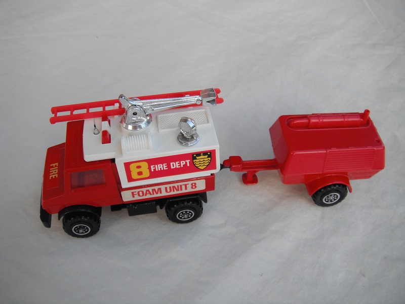 3. Red Unimog/wht canopy/matt blk base/hole/England/clr wind/red int/red compr/England/blk tow eye/Hood lbl typ 1/Fire Dept 8/Foam Unit 8 in red on white background.