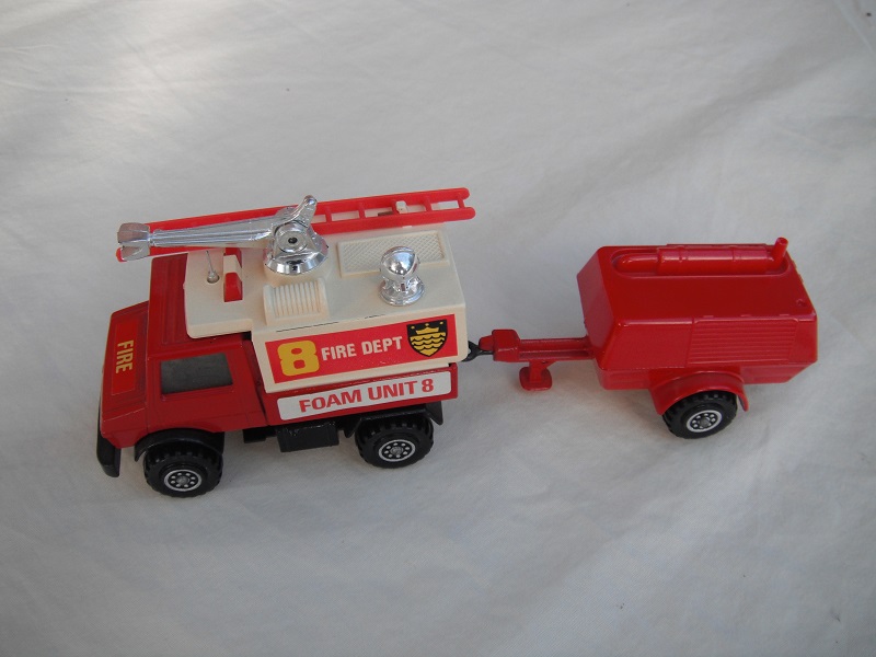 2. Red Unimog/wht canopy/matt blk base/no hole/England/clr wind/blk int/red compr/England/blk tow eye/Hood lbl typ 1/Fire Dept 8/Foam Unit 8 in red on white background.