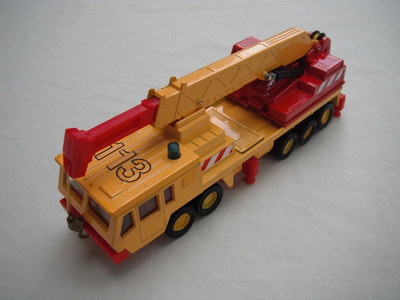 6. Dk.yel body/ribbed roof/red China base/yel 8 dot disc whls/clr wind/red int/red crane cab/amb wind/dk.yel boom/red ext/gld hook/yel cable/113, red &amp; wht stripes.