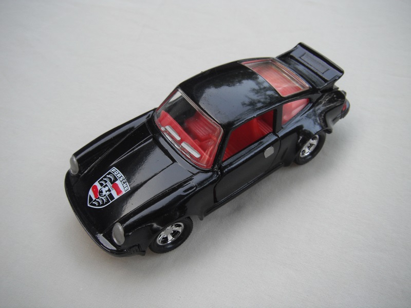 31. Black body/black base/red int/red steering/clear windows/turbo on sides/black, red &amp; white logo on hood/Macau cast.