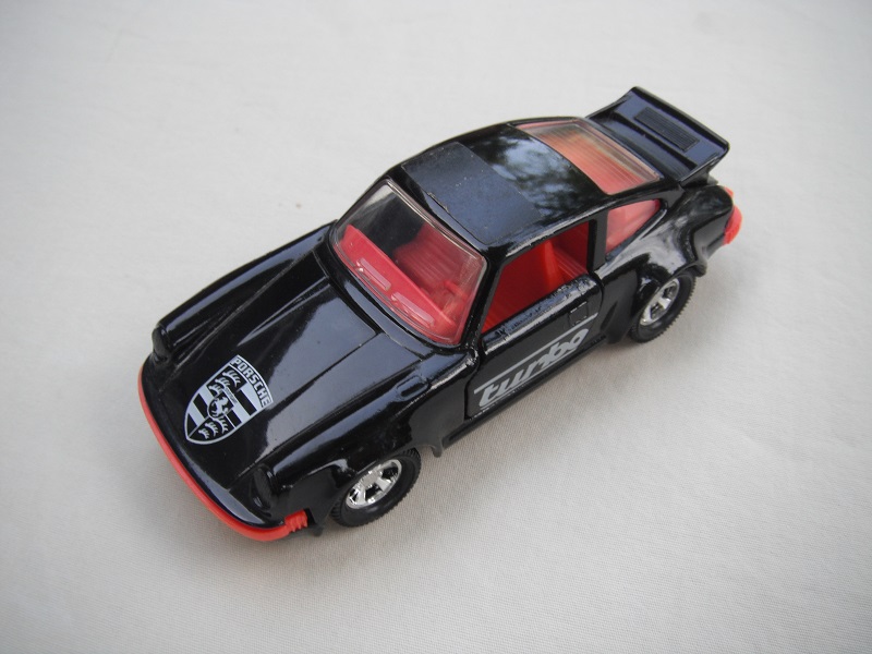 24. Black body/black base/red int/red steering/clear windows/turbo on sides/logo on hood/half black roof label/England cast.