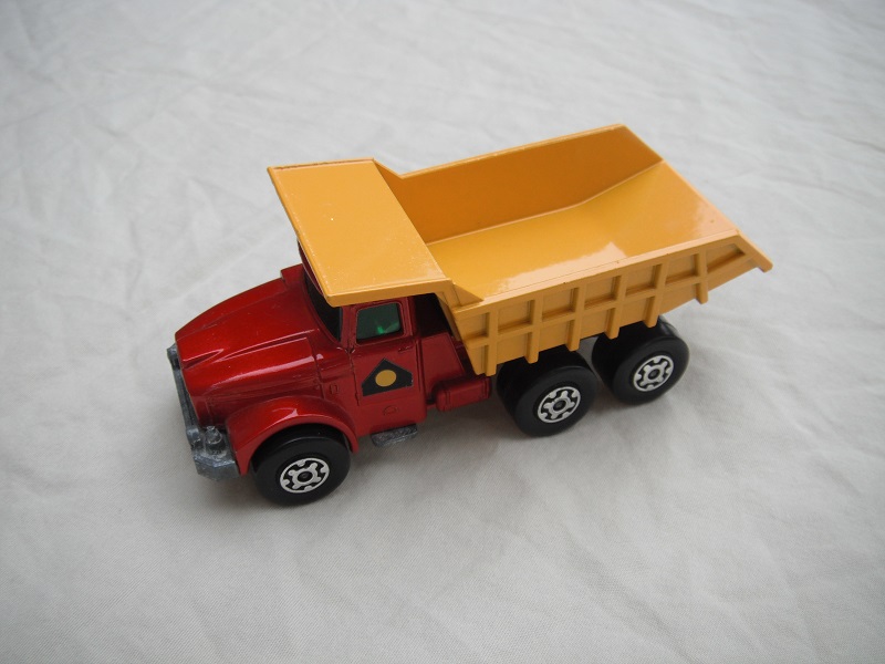 25.Met.red body/blk rad/drk.yel tipper/lrg stopper/rear brace/1971 Lesney base/LMC whls/opn tan xle holder/grn wind/yel circle in blk.triangle lbl.