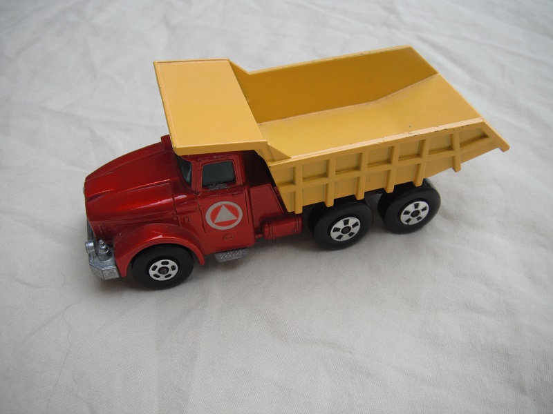 20.Met.red body/blk rad/yellow tipper/lrg stopper/rear brace/1971 Lesney base/5 dash frnt whls/opn tan xle holder/lt.grn wind/triangle pointed up lbl.