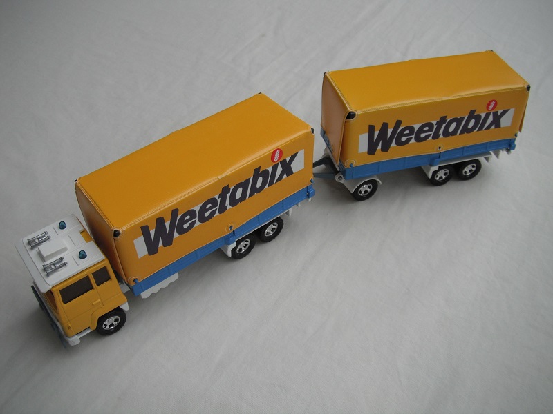 2. Yel &amp; blu cab/wht base/blu dome lts/amb wind/mag whls/gry rad grill/blu &amp; wht tlr/Weetabix/yel canvas/gry tow bar/wht tow hook.