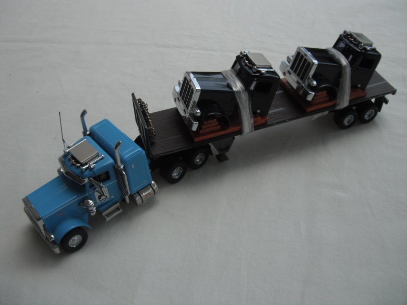 1. Powder blue cab/black chassis/black rubber tires/brown flatbed trailer/two black Peterbilt cabs for load/&quot;Pac Lease&quot; tempa.