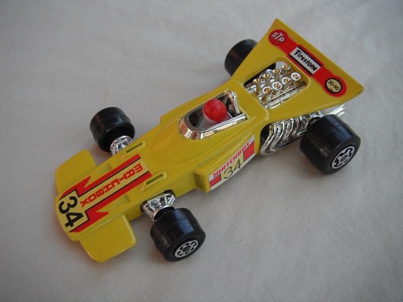 12.Dk.yel body/unpainted Speedkings base/wider rear wheels/white driver w/red helmet/&quot;Matchbox 34&quot; yellow labels.