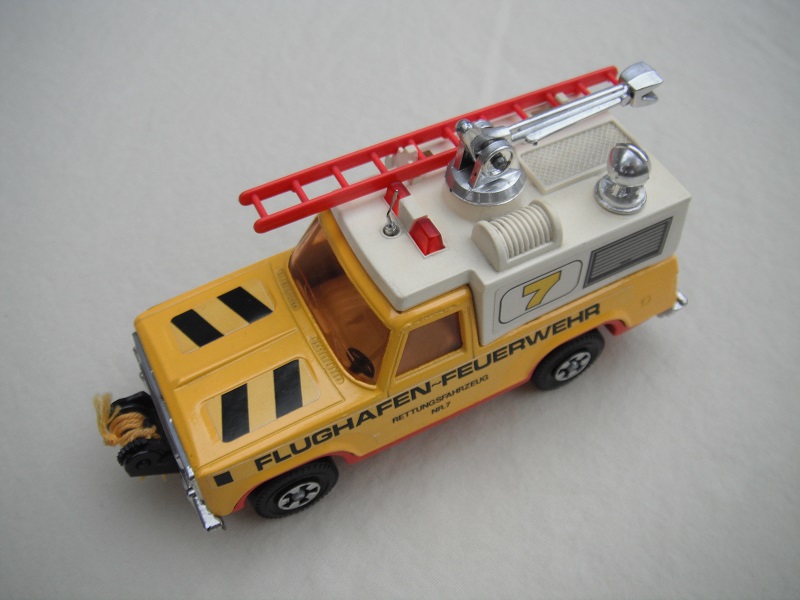 21. Yel body/wht canopy/red base/red dome lts/red ladder/amb windows/sml steering/&quot;Flughafen-Feuerwehr&quot;/7 &amp; stripes label/yel cable.