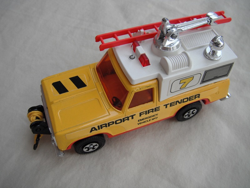 6. Yel body/wht canopy/red base/red dome lts/red ladder/reddish amber windows/sml steering/&quot;Airport Fire Tender&quot;/7 &amp; stripes lbl/yel cable.