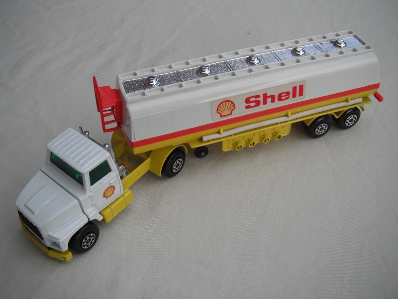 9. Wht cab/lt.yel bse/gld xle cvr f.fwd/wht 5th whl typ B/ss/grn wind/trailer w/yel base/Shell middle/wht hoses/chrm top/dk.brn opn xle cvr/red band &amp; plastics.