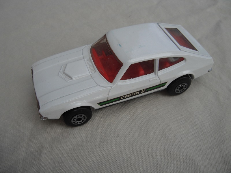 E1. White body/wht roof/matt blk speedkings base/5 arch whls/red interior/clear windows/green Capri 11 labels.