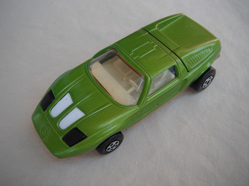 E14. Dk. lime green body/dark gold base/five spoke wheels/lt.amber windows/white interior/black headlights.