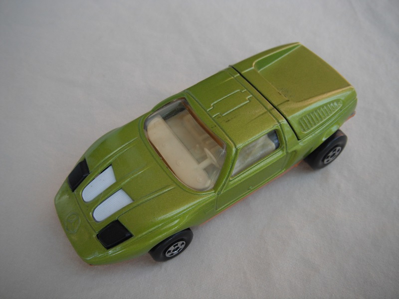 E12. Lt. lime green body/dark gold base/five spoke wheels/light amber windows/black headlights.