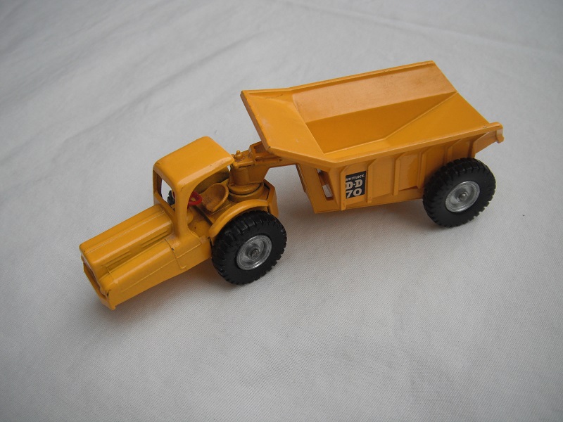 1. Yellow body/crimped rivet on base/silver wheels/black tires/rounded axles/red steering wheel/side decals.