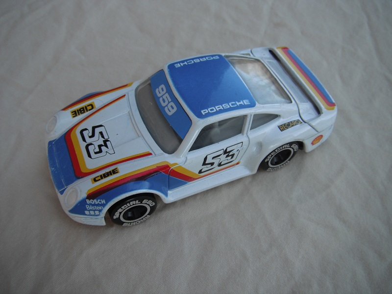 4. White/blue w/red/yel stripes/black base Macau/gray interior/clear windows/chromed lettering on wheels/Porsche #53.